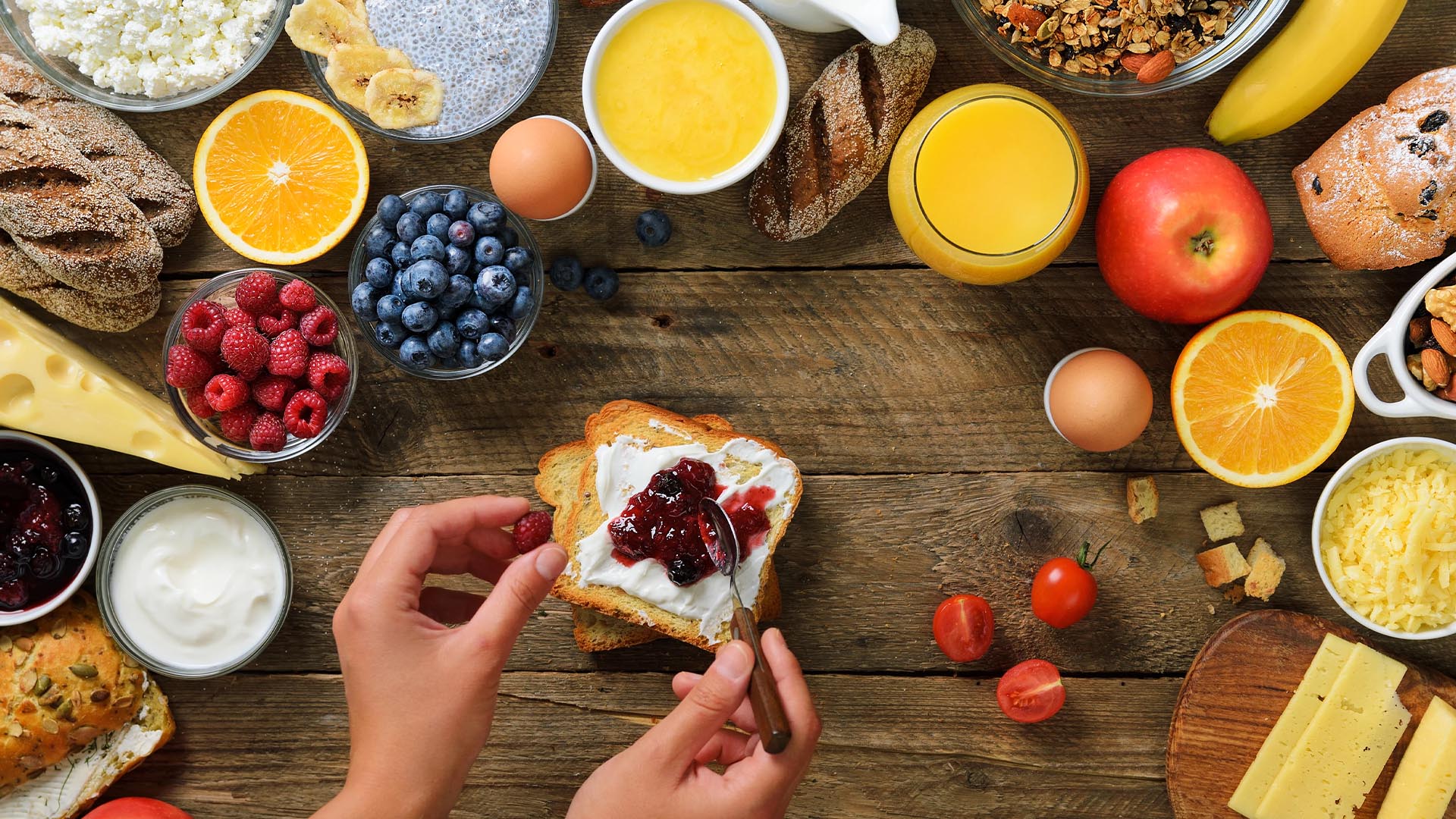 Rustic breakfast spread featuring toast with Moran’s homemade jam, fresh fruit, yogurt, juice, and cheese